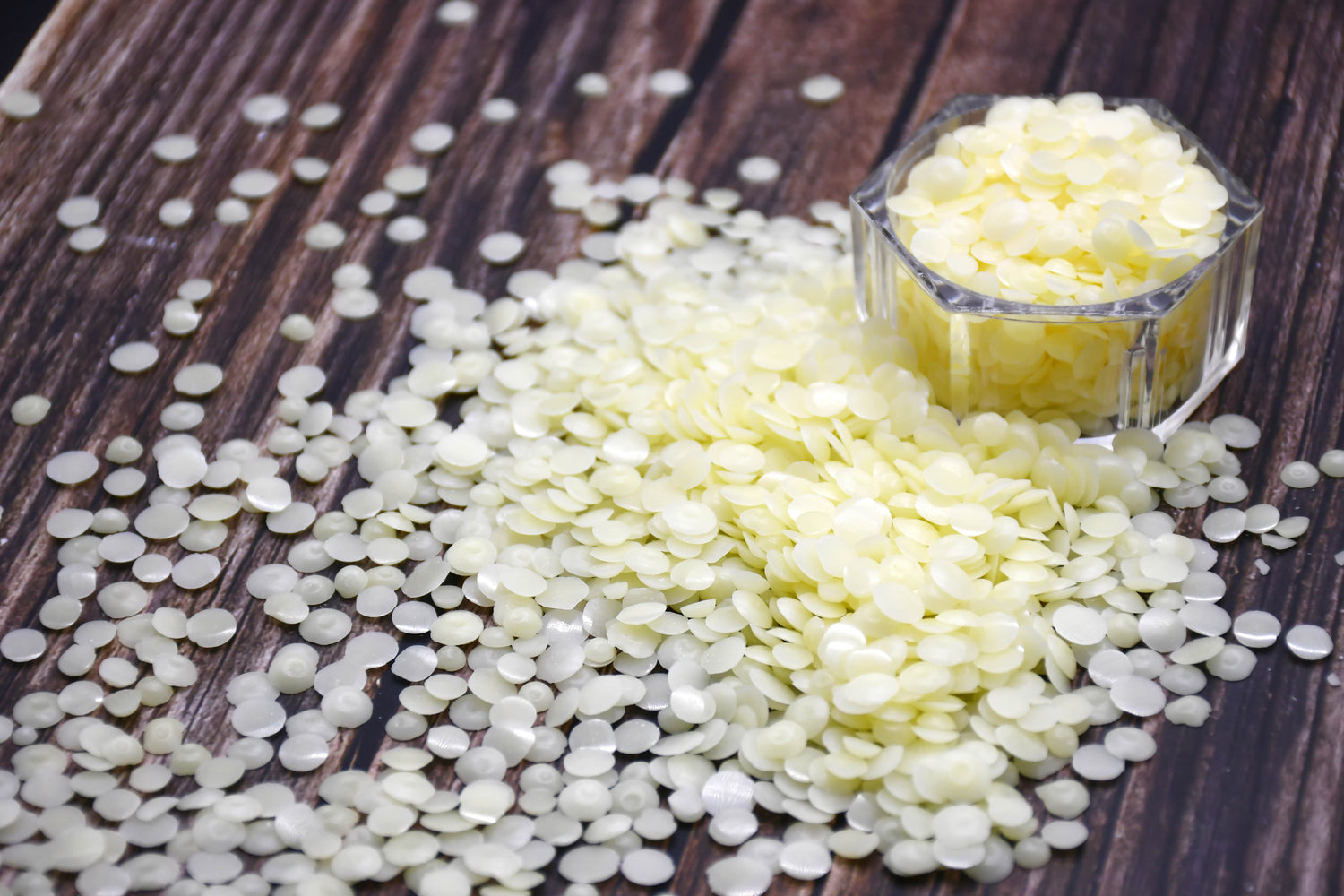 White and yellow resin beads on a wooden surface